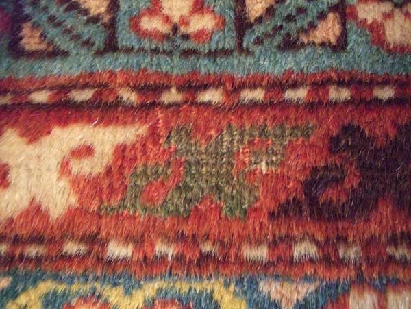 Knot Heads showing in some areas of the rug: Note the Green design element (center)