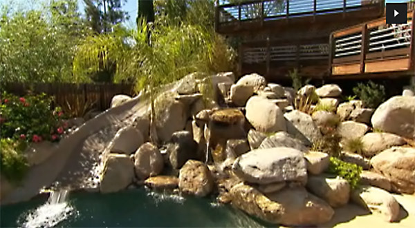 Outdoor swimming pool with waterfall